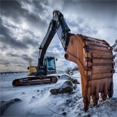 Excavator at snow covered construction site